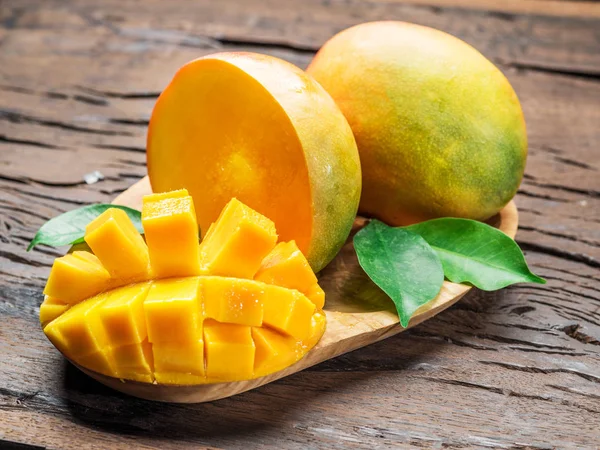 Mango meyve ve eski ahşap masa mango dilimleri. — Stok fotoğraf