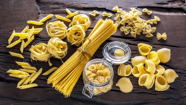 Typer av olika pasta på tabellen trä. — Stockfoto