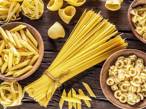 Typer av olika pasta på tabellen trä. Ovanifrån. — Stockfoto