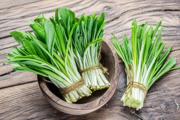 Young fresh wild garlic on the wooden table. — Stock Photo, Image