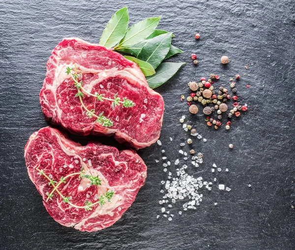 RIB eye steak med kryddor på den svarta bakgrunden. — Stockfoto