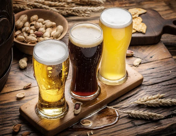 Vasos de cerveza y aperitivos en la mesa de madera . —  Fotos de Stock