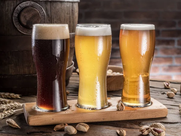 Vasos de cerveza y barril de cerveza en la mesa de madera. Cervecero artesanal —  Fotos de Stock
