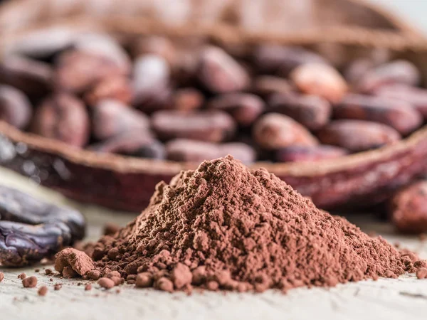 Cocao en poudre et fèves de coca sur la table en bois . — Photo