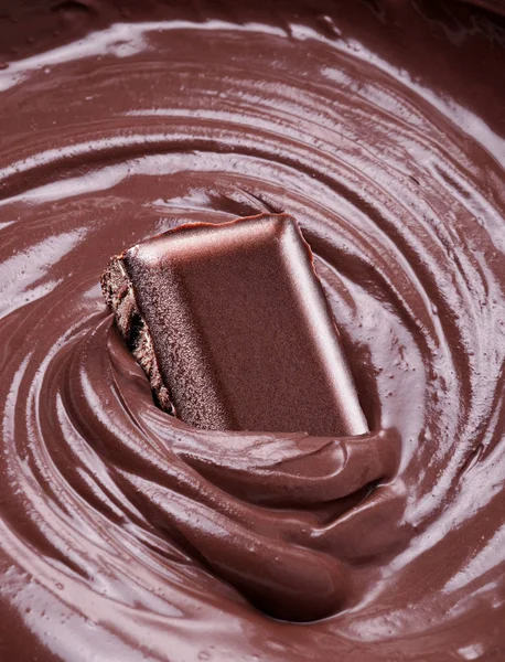 Cioccolato fuso e pezzo di barretta di cioccolato intinto in esso . — Foto Stock