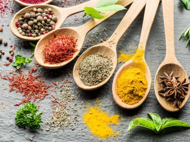 Ahşap kaşıklardaki renkli baharatların çeşitli çeşitleri.
