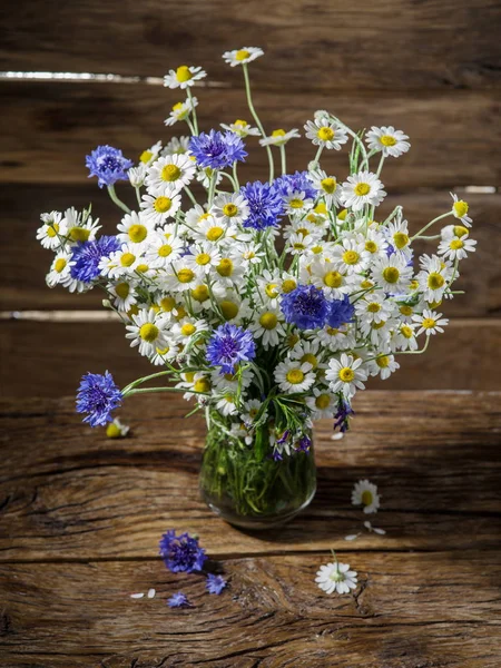 Buquê de camomilas e flores de milho no vaso na madeira — Fotografia de Stock