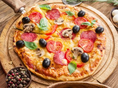 Mantar, salam ve domates pizza.