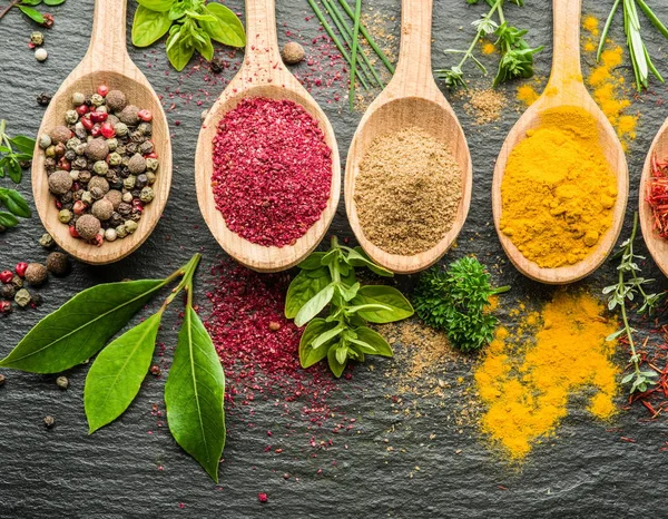 Assortment of colorful spices in the wooden spoons. — Stock Photo, Image