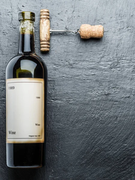 Wine bottle and corkscrew on the graphite board. — Stock Photo, Image