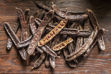 Keçiboynuzu bakla ve ahşap masa keçiboynuzu fasulye.