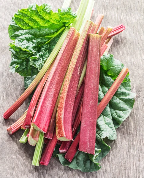 Essbare Rhabarberstengel auf dem Holztisch. — Stockfoto