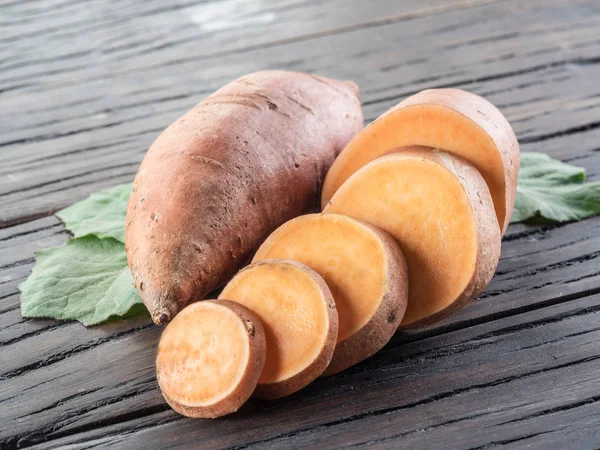 Batatas doces na velha mesa de madeira. — Fotografia de Stock