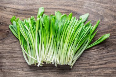 Ahşap masa üzerinde genç taze yabani sarımsak.