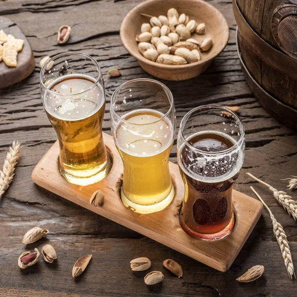 Vasos de cerveza y aperitivos en la mesa de madera . — Foto de Stock