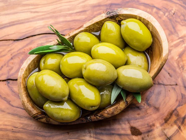 Olive da tavola intere nella ciotola di legno sul tavolo . — Foto Stock