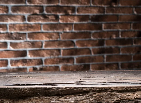 Oude houten lege tabel en bakstenen muur op de achtergrond. — Stockfoto