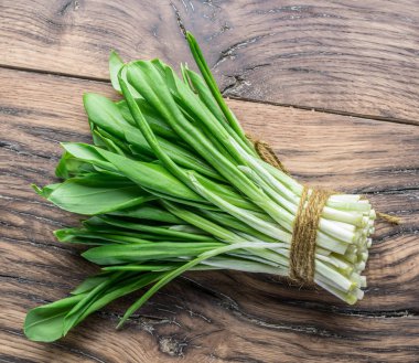 Ahşap masa üzerinde genç taze yabani sarımsak.