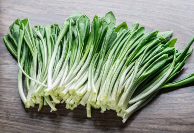 Ahşap masa üzerinde genç taze yabani sarımsak.