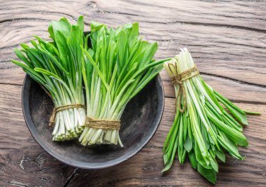 Ahşap masa üzerinde genç taze yabani sarımsak.