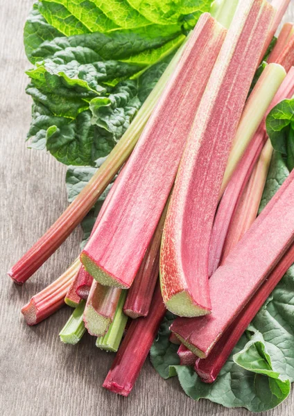 Edible rhubarb stalks on the wooden table. — Stock Photo, Image