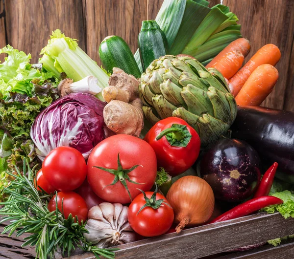 Fresh multi-colored vegetables in wooden crate. Top view. — Stock Photo, Image