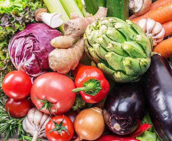 Fresh multi-colored vegetables in wooden crate. Top view.