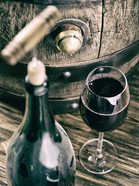 Opening wine bottle. Oak wine keg at the background. — Stock Photo, Image