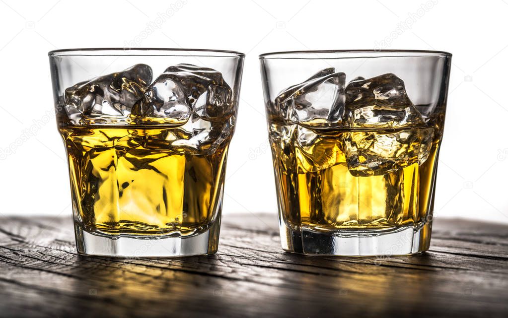 Whiskey glasses or glasses of whiskey with ice cubes on the wood
