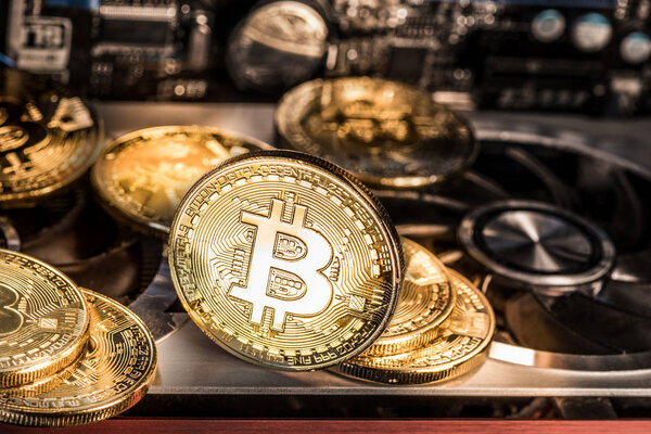Shiny physical bitcoins and record-keeping equipment. Mining far