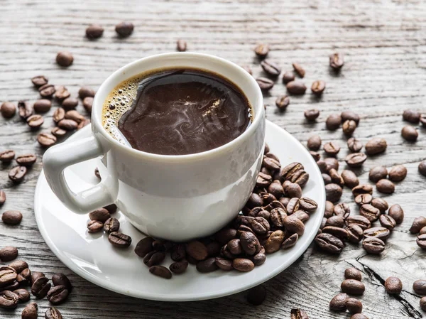 コーヒー豆に囲まれたコーヒー カップ。トップ ビュー. — ストック写真
