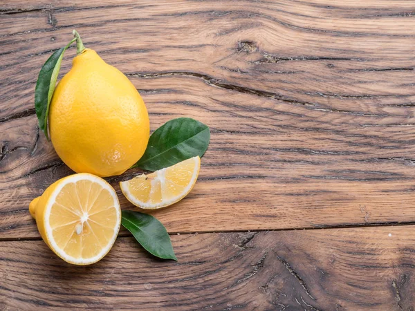 木製の背景に熟したレモンとレモンを残します。トップ ビュー. — ストック写真