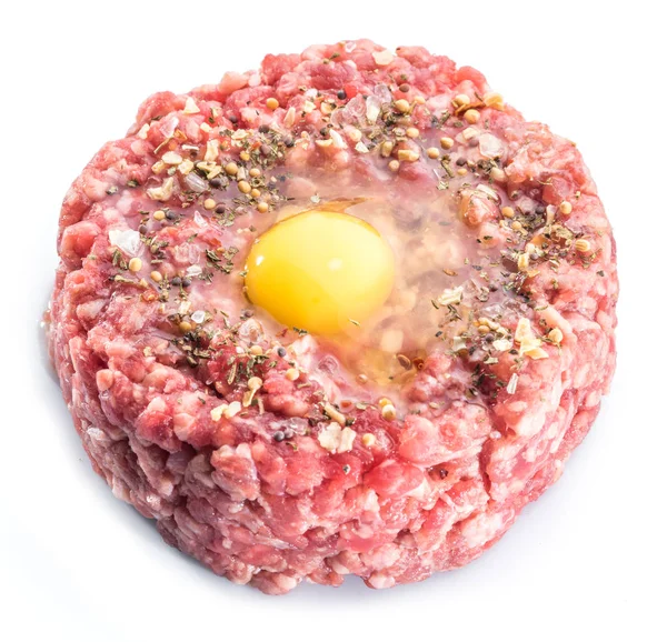 Chuleta molida o hamburguesa cruda con yema de huevo de codorniz y condimento — Foto de Stock