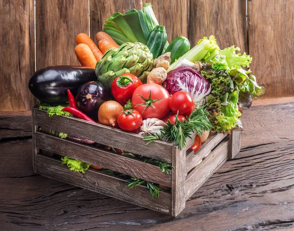 Verduras multi-coloridas frescas em caixa de madeira. Fundo de madeira — Fotografia de Stock