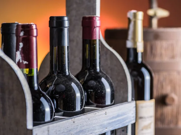 Botellas de vino en caja de madera y barril de vino de roble . — Foto de Stock