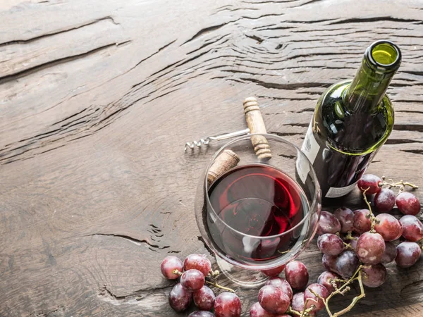 Copo de vinho, garrafa de vinho e uvas em fundo de madeira. Vinho — Fotografia de Stock