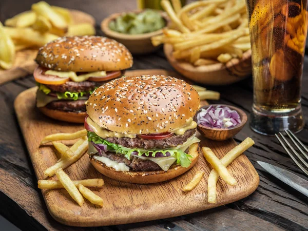 Hamburgery i frytki na drewnianej tacy. — Zdjęcie stockowe