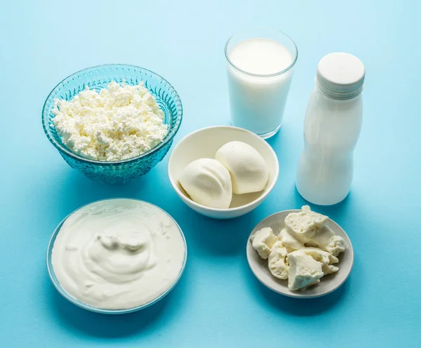 Eiweißprodukte: Käse, Sahne, Milch, Eier auf blauem Hintergrund — Stockfoto