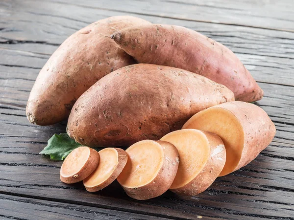 Sweet potatoes on the old wooden table. — Stock Photo, Image