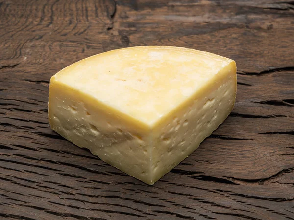 一块自制的奶酪在木质背景上. — 图库照片