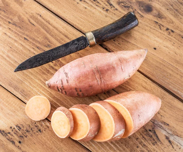 Batatas doces na velha mesa de madeira. — Fotografia de Stock