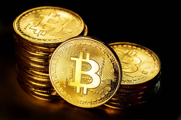 Glänzende physische Bitcoins auf schwarzem Hintergrund. Blockchain-Technologie — Stockfoto