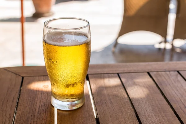 Copo de cerveja leve na mesa de madeira . — Fotografia de Stock