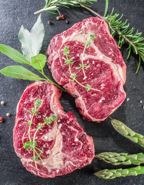 Rib eye steak, a fűszerek, a fekete háttér. — Stock Fotó