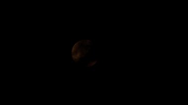 Bulutların arasından gece gökyüzüne dolunay taşır.