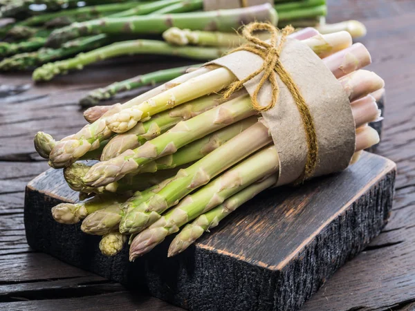 Paquetes de espárragos verdes y blancos sobre tabla de madera. Orgánica fo —  Fotos de Stock