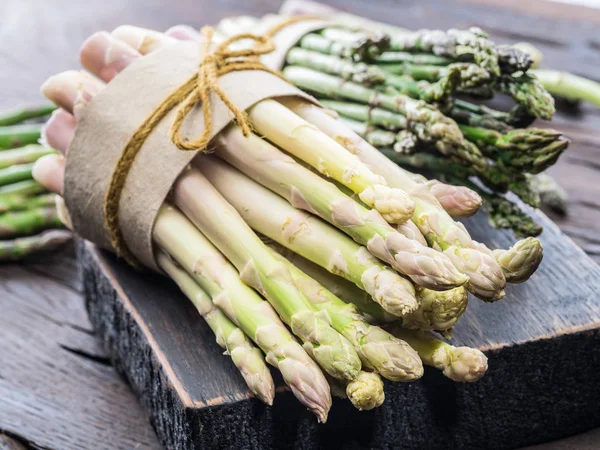 Bundels van groene en witte asperges op een houten bord. Biologische fo — Stockfoto