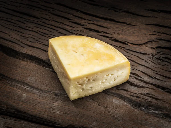 Ahşap zemin üzerine ev yapımı peynir parçası. — Stok fotoğraf