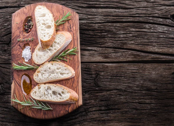 Sneetjes ciabatta met rozemarijn kruid op de houten dienblad — Stockfoto