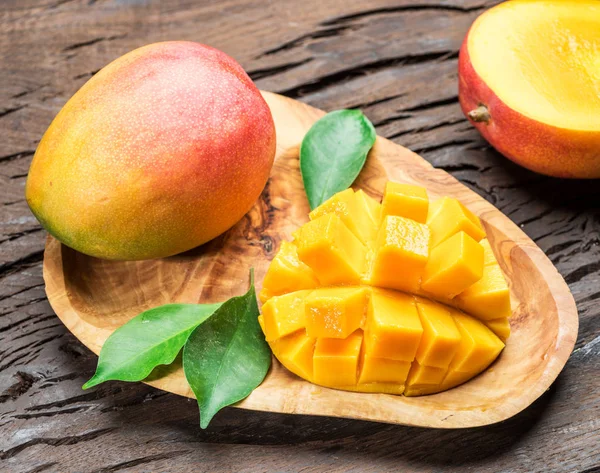 Mango gyümölcs és mangó szeleteket a régi fából készült asztal. — Stock Fotó